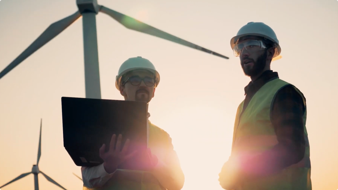 Workers with sun and wind turbine in background