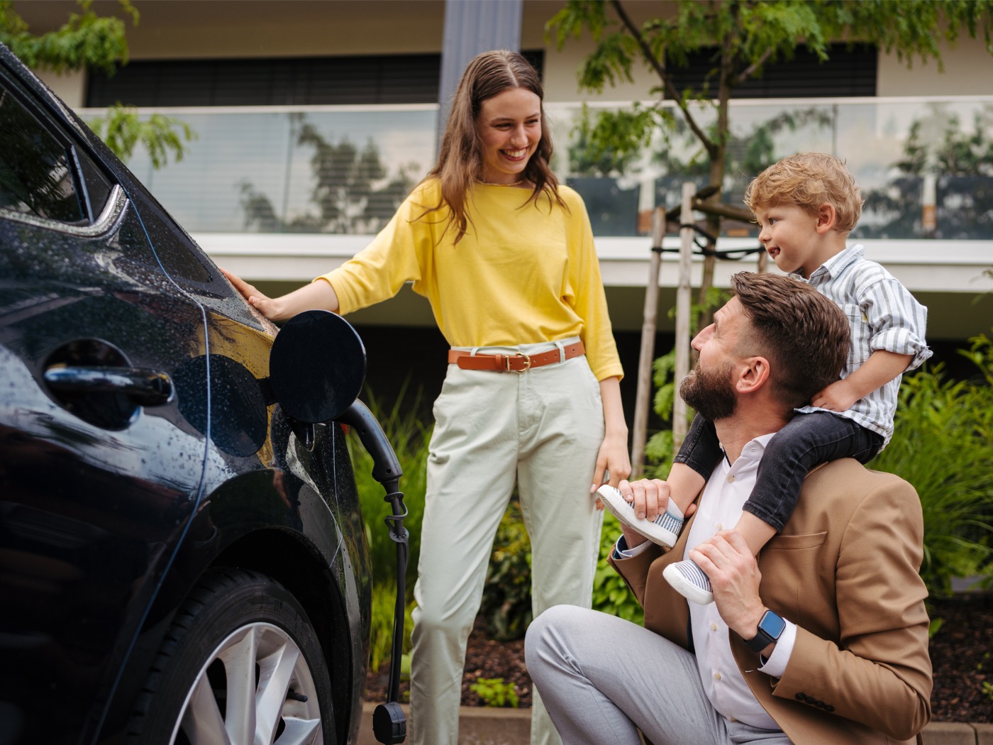 Family Outside Smiling While Charging EV