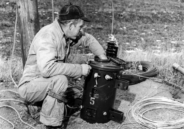 Black and white photo of lineman working on transformer