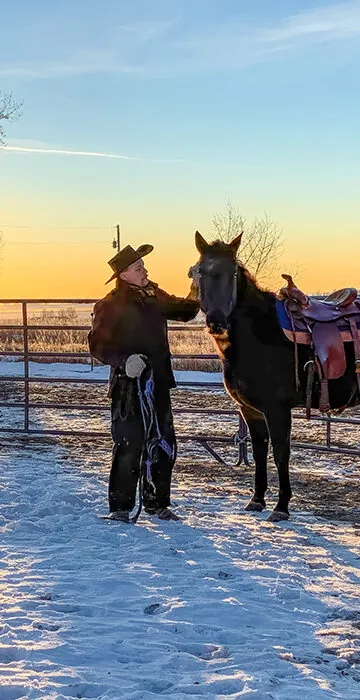 National Cooperative Month Header - man stands in field next to horse.