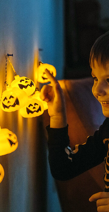 Kid with Halloween pumpkin lights - Spook-tacular Energy Savings