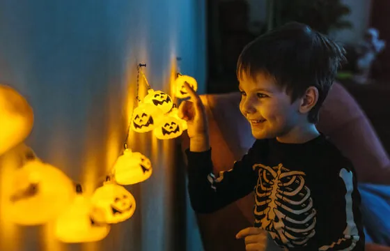 Kid with Halloween pumpkin lights - Spook-tacular Energy Savings