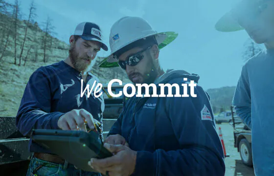 PVREA linemen working in the field with 'We commit' text overlay.